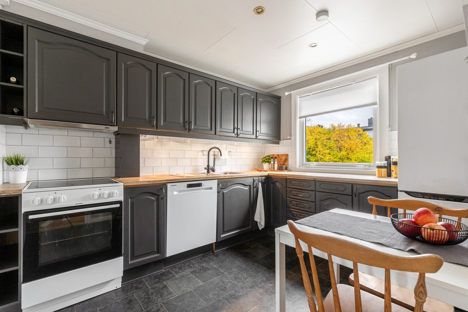 Kjøkkenet har godt med skap og benkeplass Galleribilde