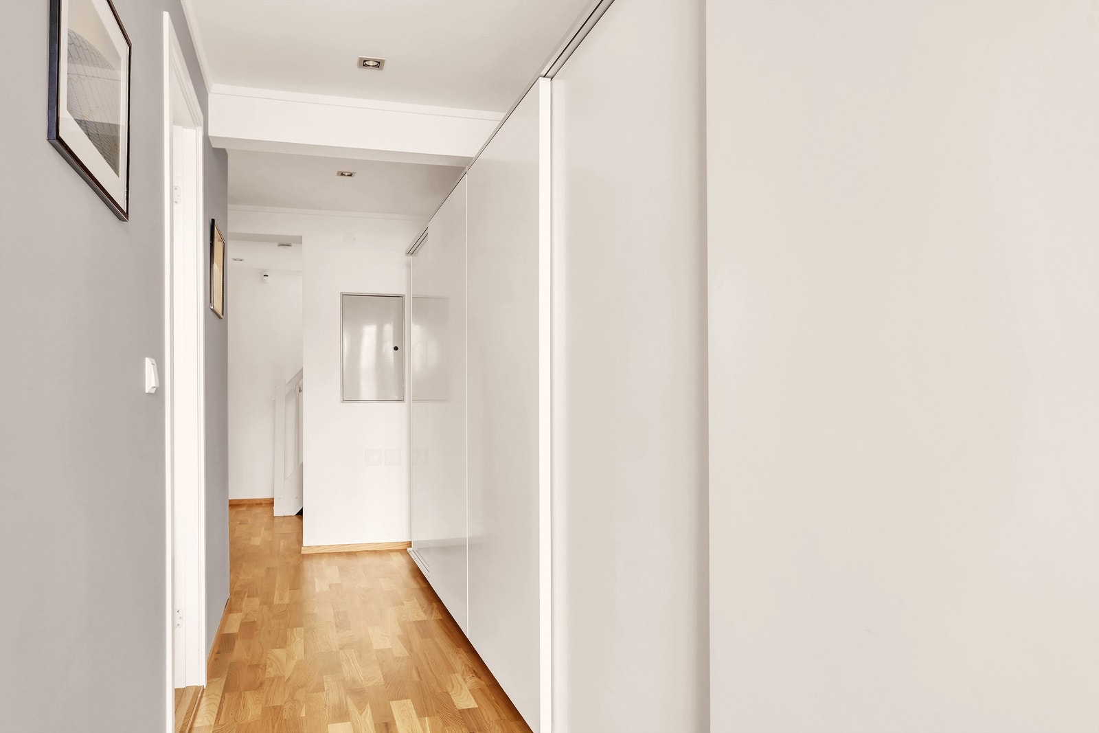 Gang i underetasjen har downlights belysning, lyse overflater og parkettgulv Galleribilde