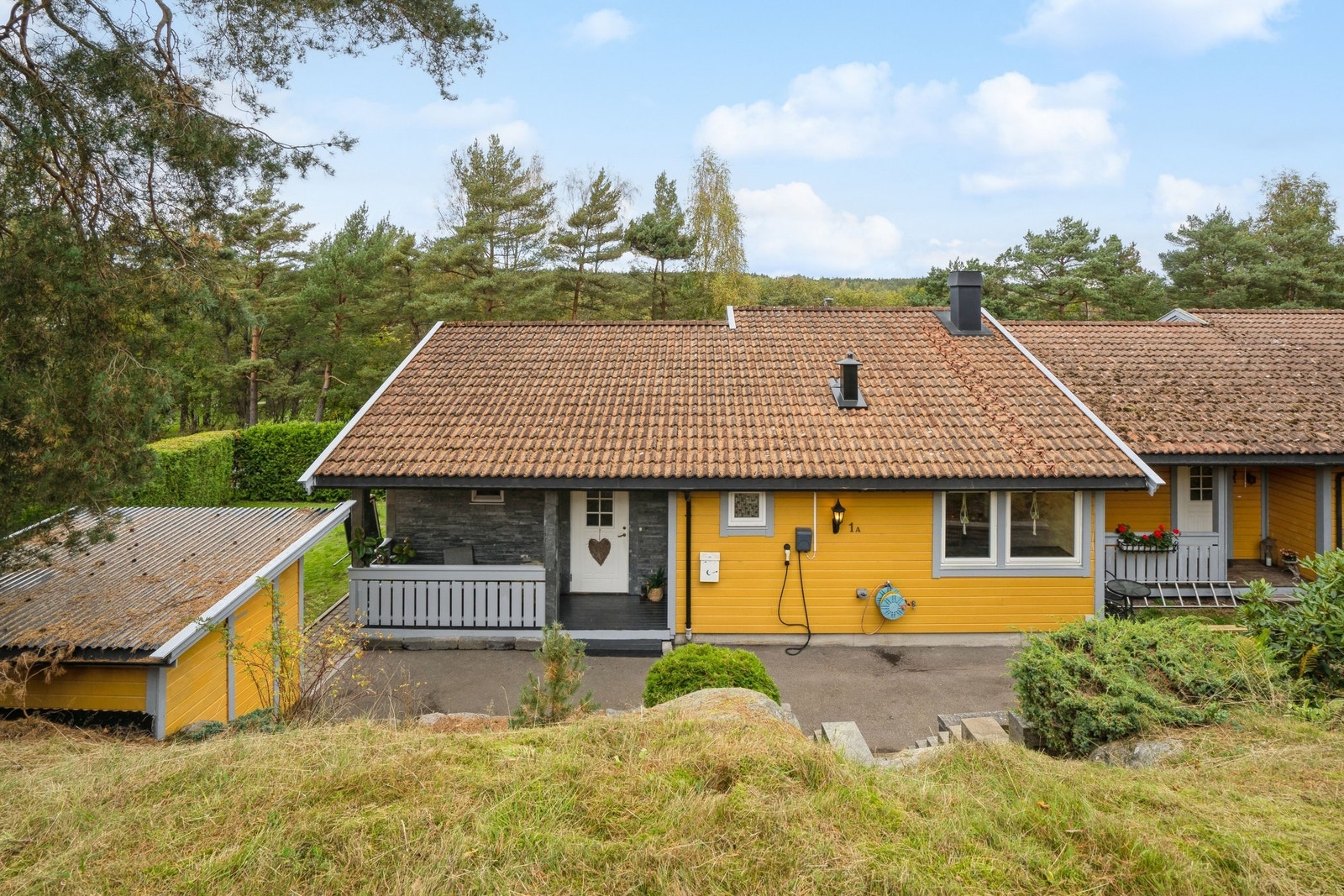 Boligen ligger avskjermet innerst i rekke med egen bod og innhekket hage Galleribilde