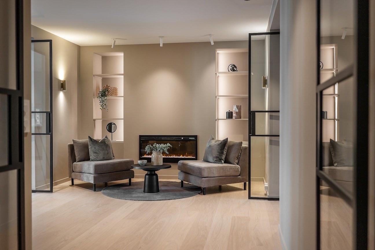 Hallen har en moderne elektrisk peis med varmefunksjon. Stemningsfulle LED-striper i bokhyllen. Galleribilde