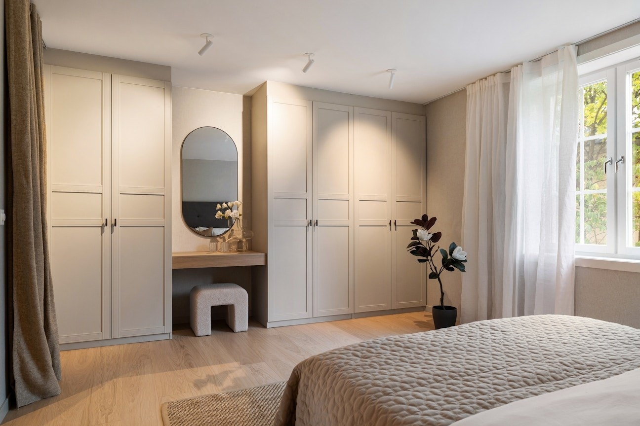 Hovedsoverommet har plassbygd garderobeskap og sminkebord, samt tapet på vegg som gir et lunt preg. Galleribilde