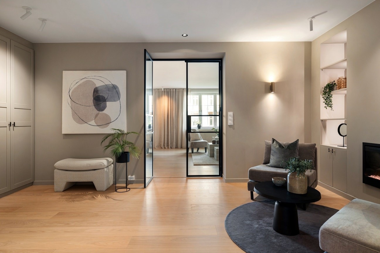 Hallen er romslig og fungerer som et naturlig bindeledd i leiligheten. Belysningen i leiligheten er nøye planlagt av interiørdesigner. Galleribilde