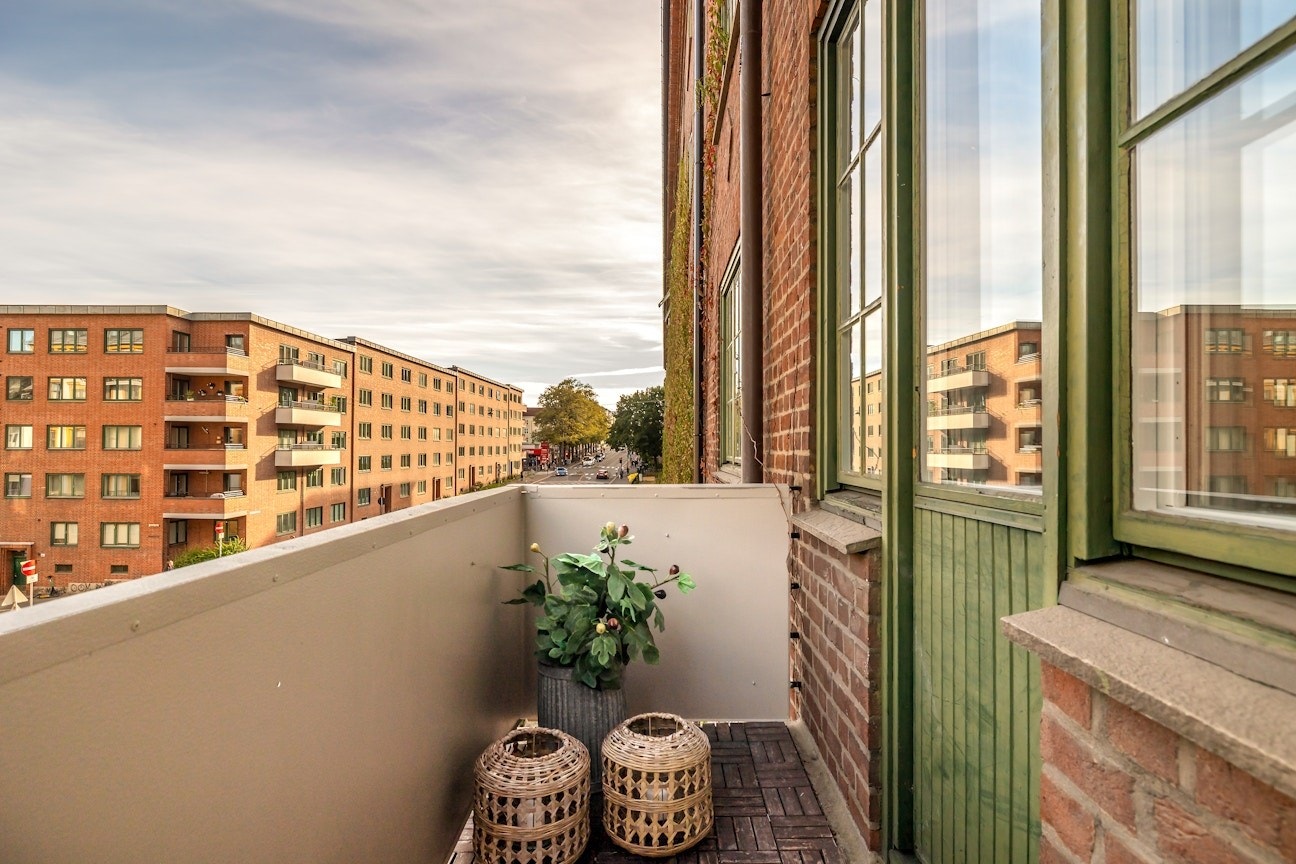 Lys og luftig hjørnebalkong med fritt utsyn - ideell for en hyggelig sittegruppe og frodige planter. Galleribilde