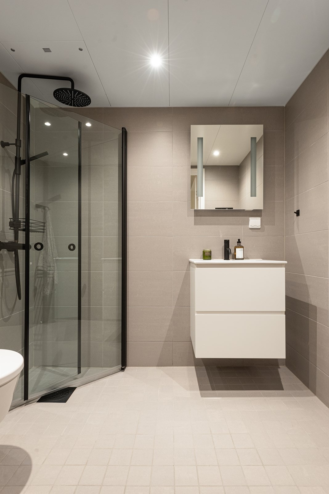 Tilhørende bad er lyst og pent med nedfelt servant, to skuffer og speilskap over vask. Galleribilde