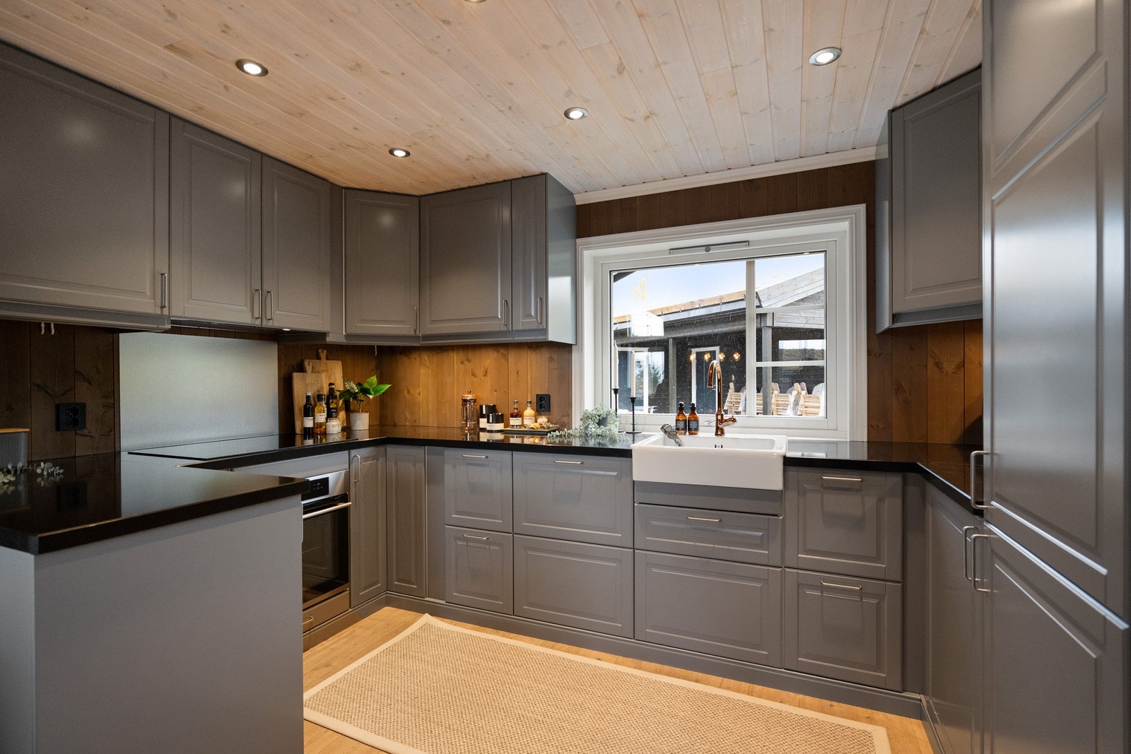 Stilrent kjøkken med god skapplass, integrerte hvitevarer og landlig vask i klassisk stil. Galleribilde