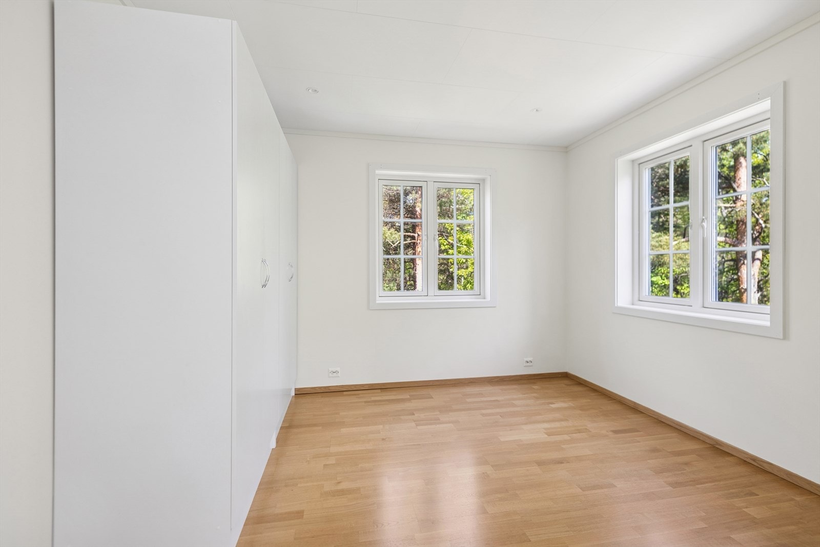 Lyst og luftig soverom i 2. etasje med garderobeskap og to vinduer som gir godt med naturlig lys. Rommet har en fin størrelse og en rolig utsikt mot grønne omgivelser. Galleribilde