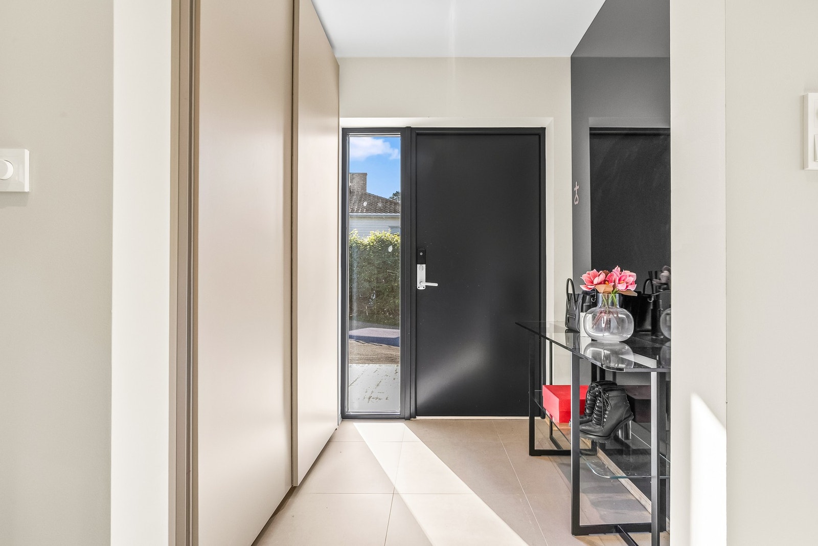 Velkommen inn til en romslig entré med fliser og skyvedørsgarderobe.