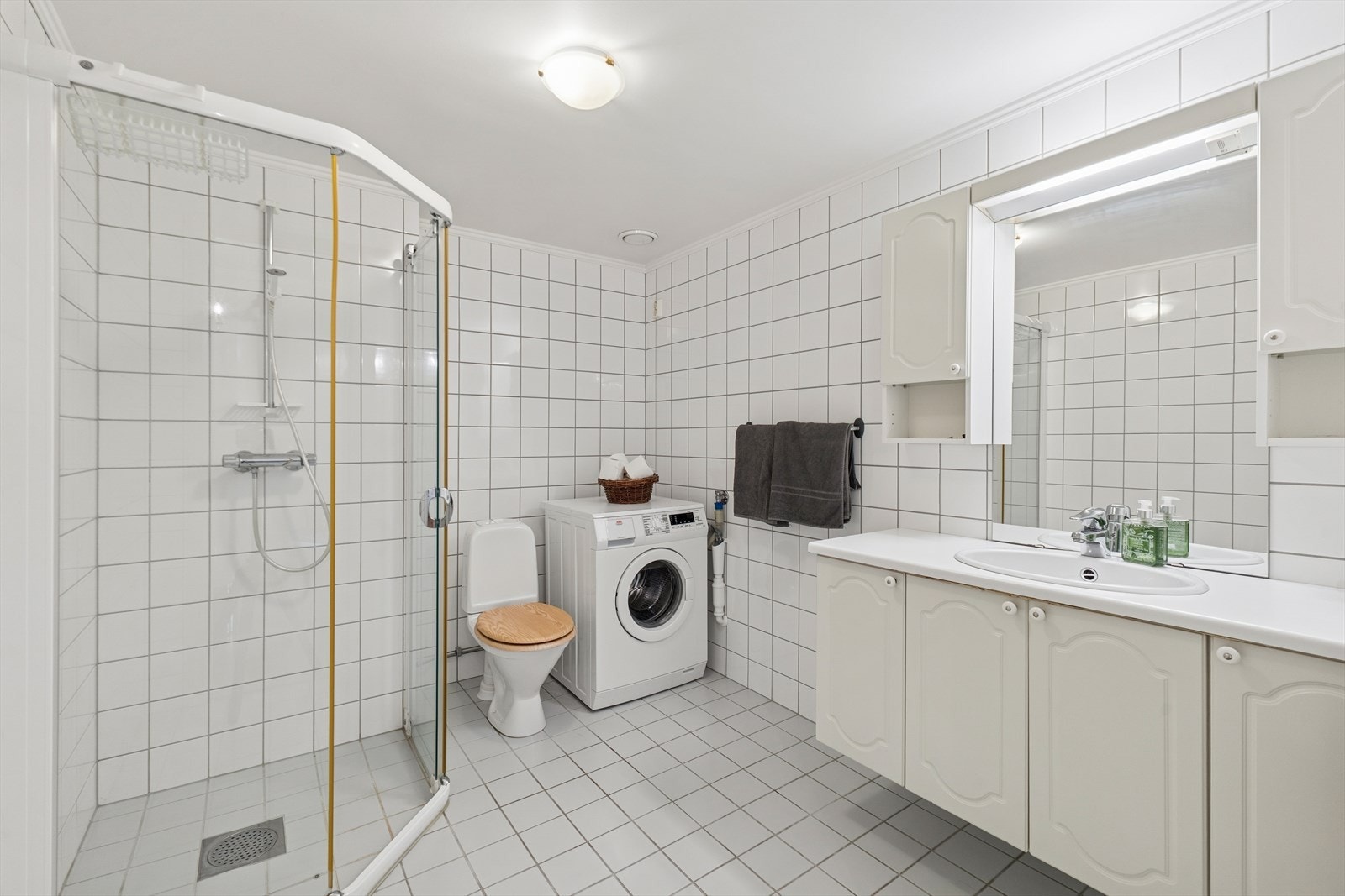 Badet fremstår som funksjonelt og velholdt, med flislagte gulv og vegger som gir et helhetlig og tidløst uttrykk. Galleribilde