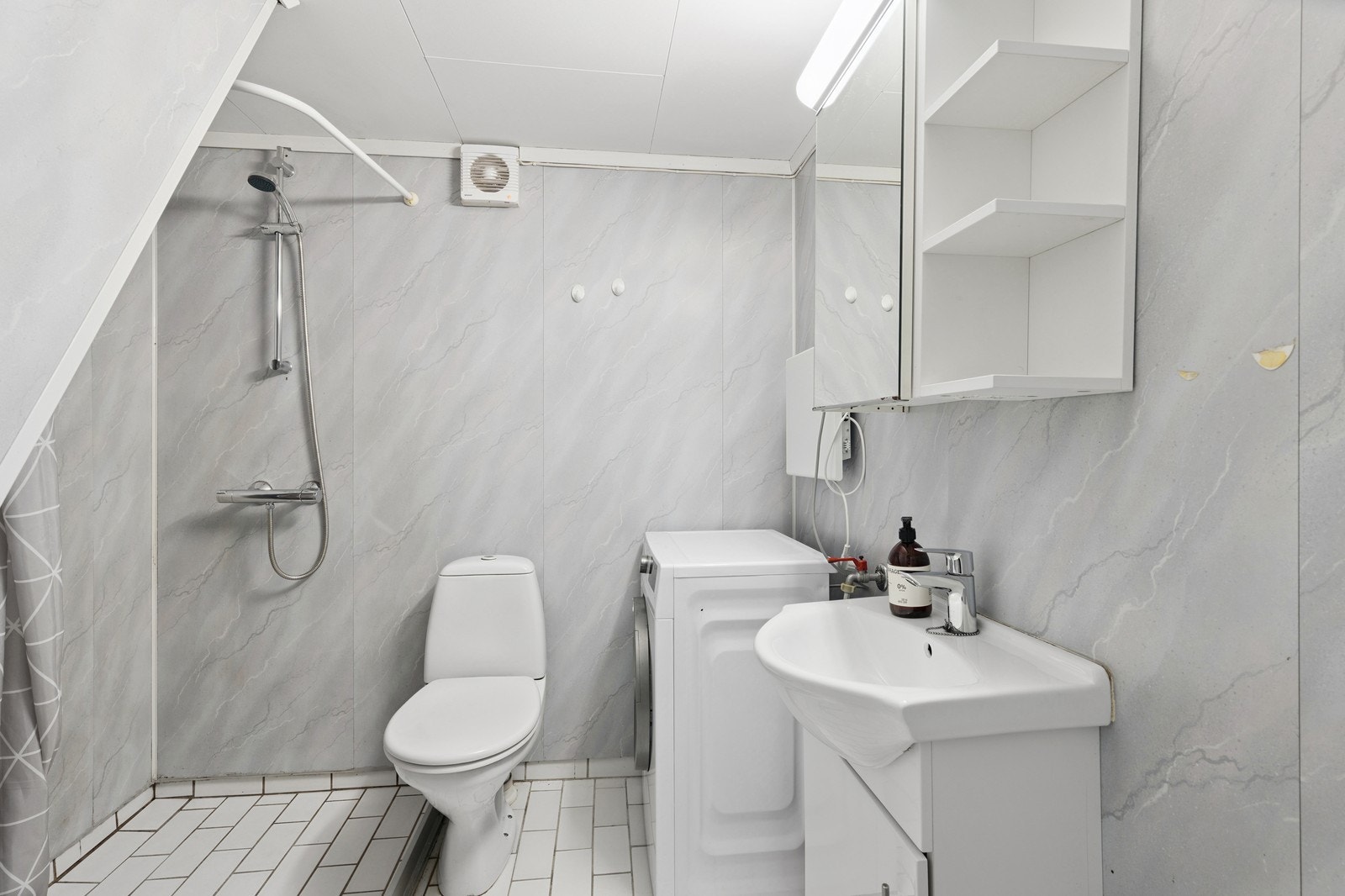 Bad med toalett, vaskemaskin, servant m/innredning og hjørnedusj Galleribilde