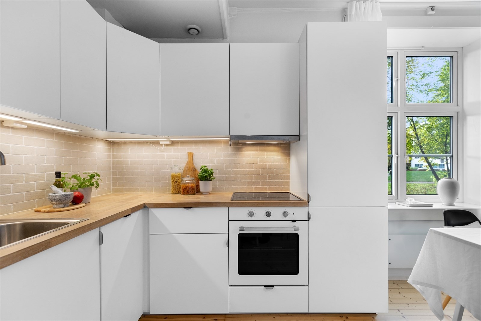 Kjøkkenet er fra Ikea og er utstyrt med slette lakkerte fronter, laminat benkeplate m/fliser over, enkel oppvaskkum, kjøkkenventilator i stål, integrert koketopp, stekeovn, oppvaskmaskin og kjøl-/fryseskap. Galleribilde