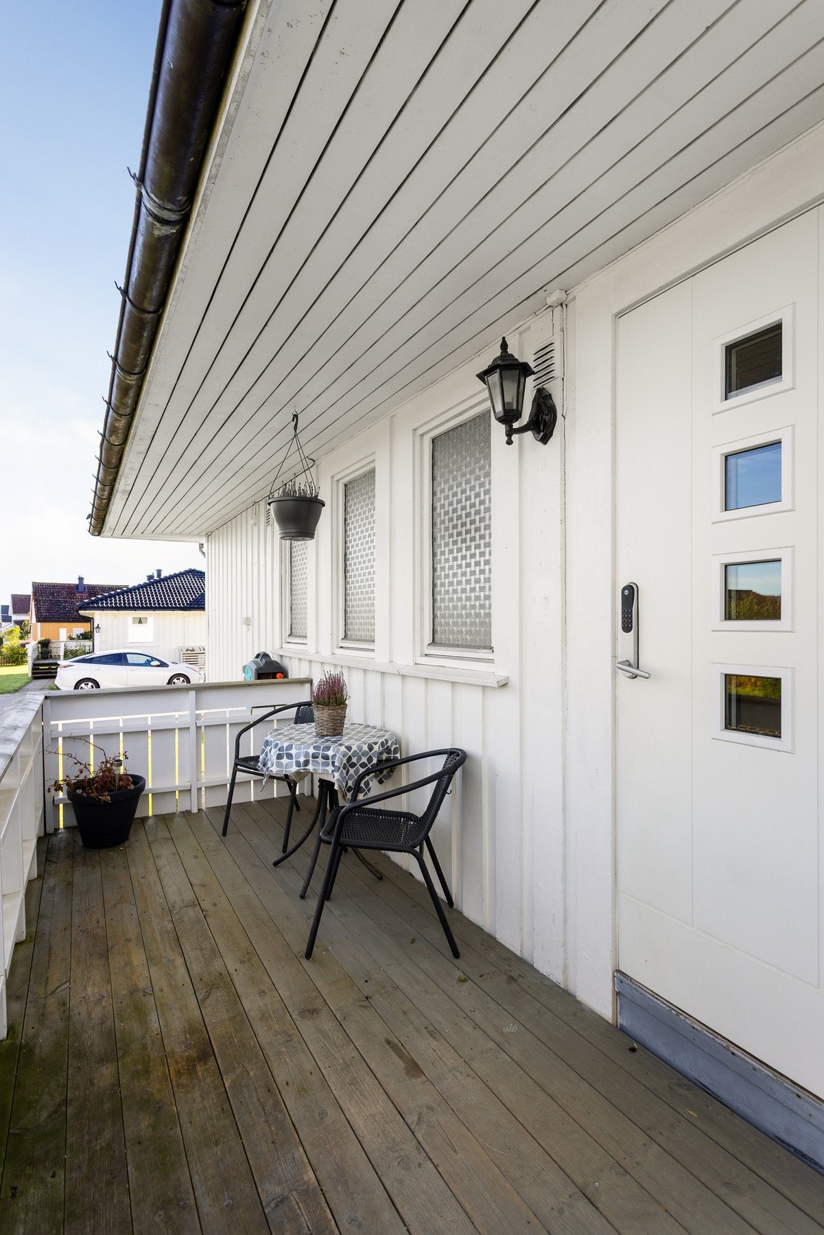 Inngangen er overbygd, utstyrt med belysning og elektronisk kodelås. Ved siden av ytterdøren er det plass til en benk eller et koselig kafésett. Galleribilde