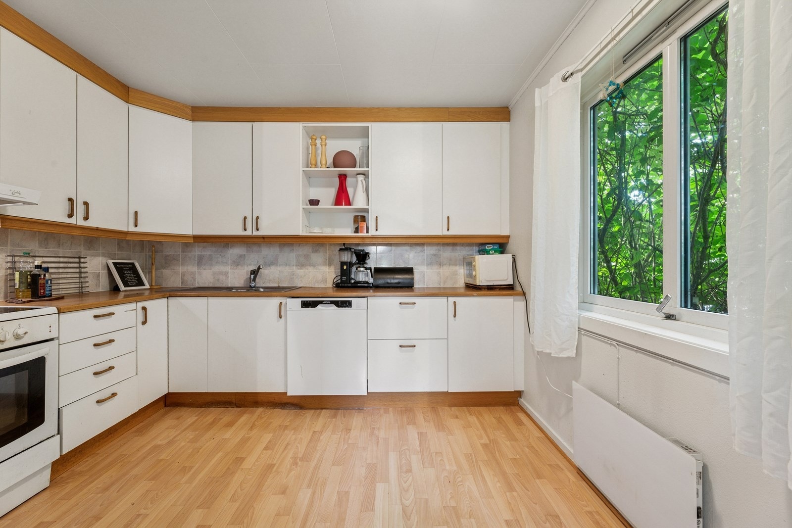 Kjøkkenet er lyst og byr på det en måtte trenge av skap-, skuff- og benkeplass. Galleribilde