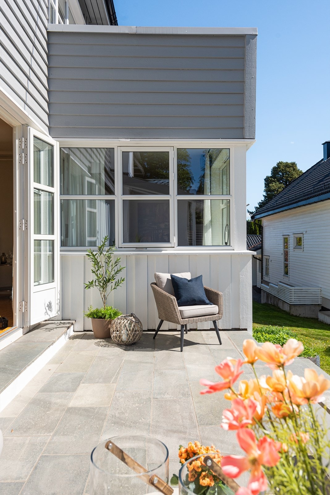 Direkte adkomst fra stue til solrik terrasse med flislagt dekke. Galleribilde