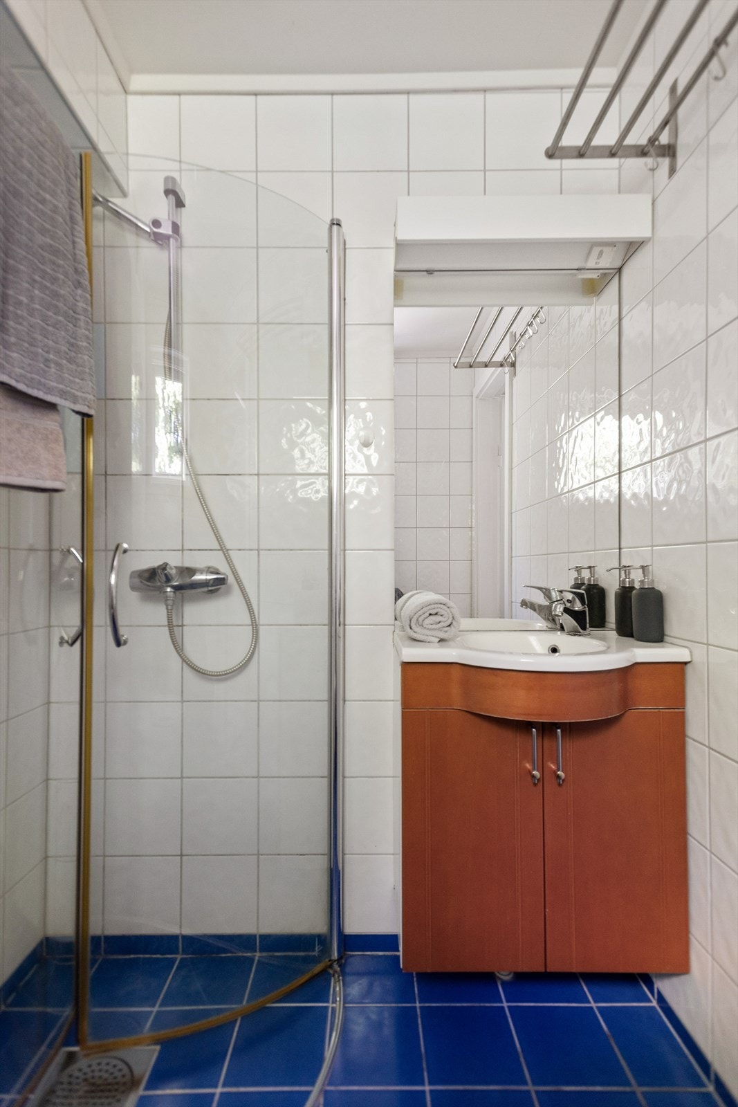 Flislagt bad tilknyttet soverom IIII med dusjhjørne og praktisk baderomsinnredning. Galleribilde