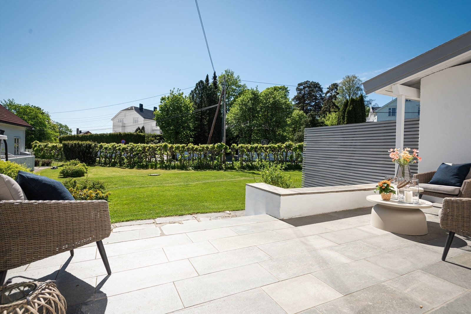 Betongterrasse med skiferstein gir en elegant overgang til frodig hage. Galleribilde