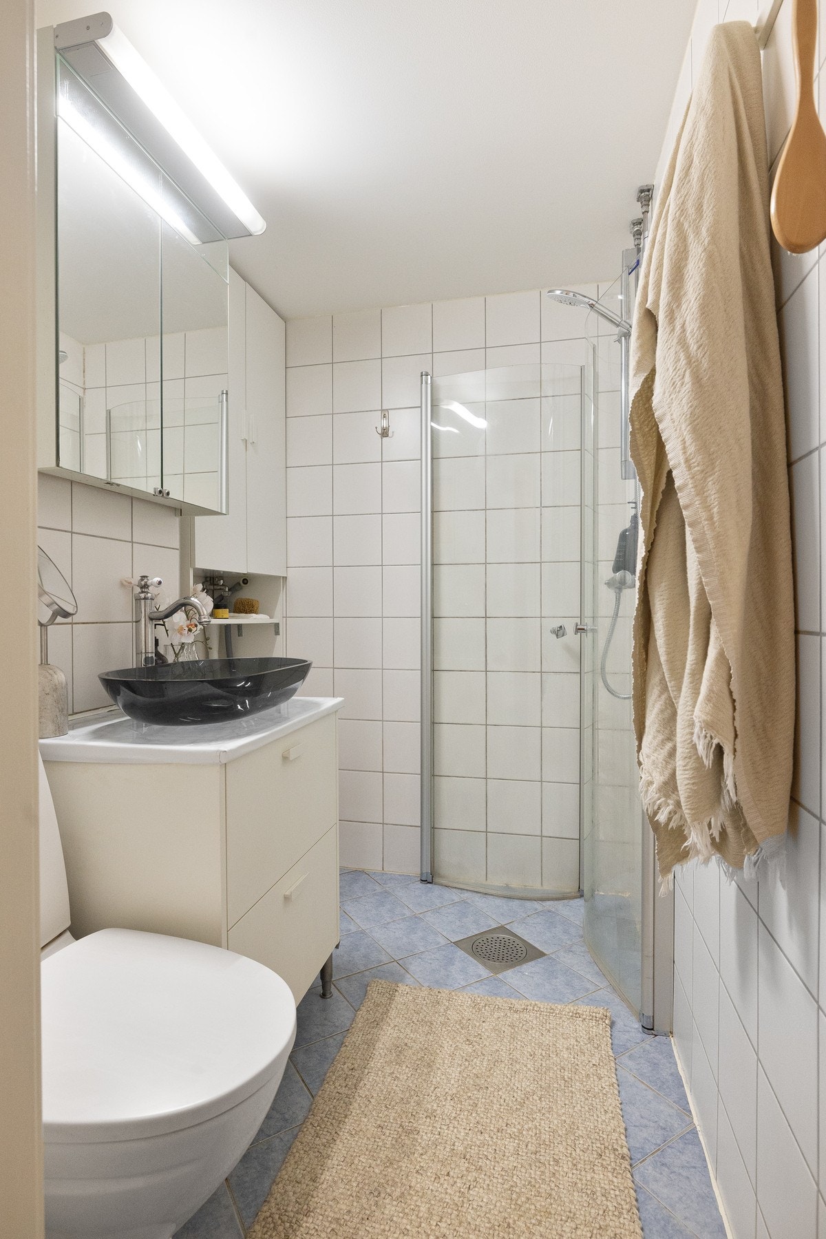 Flislagt baderom med servant og gode oppbevaringsmuligheter i servantskap, toalett og dusj. Galleribilde