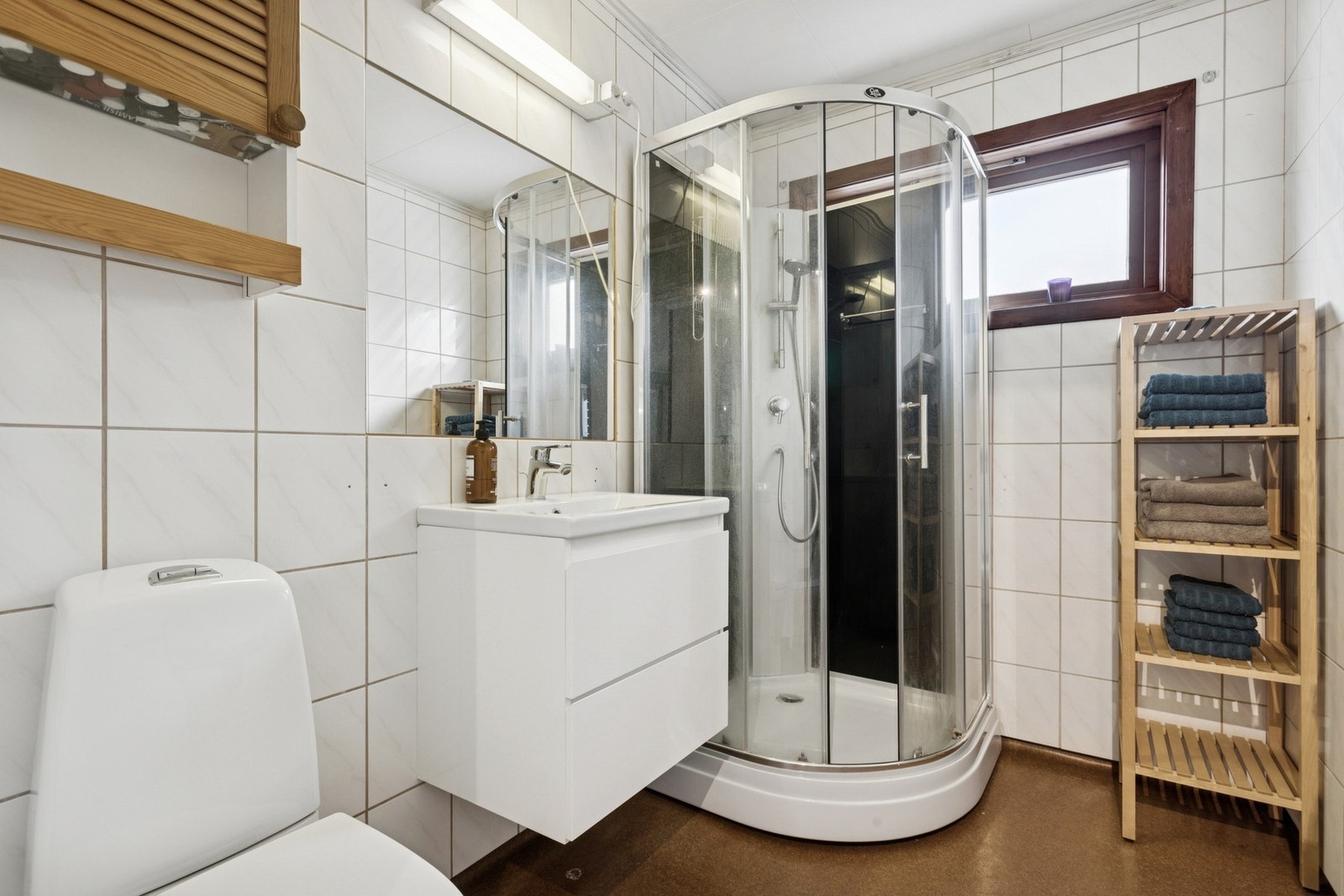 Baderommet er noe eldre og er utstyrt med dusjkabinett, klosett og servantinnredning. Galleribilde