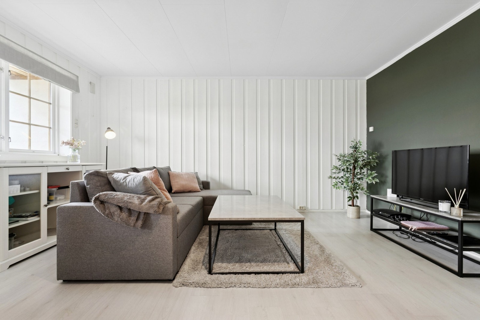 En vegg i stue er malt i moderne farge. Galleribilde