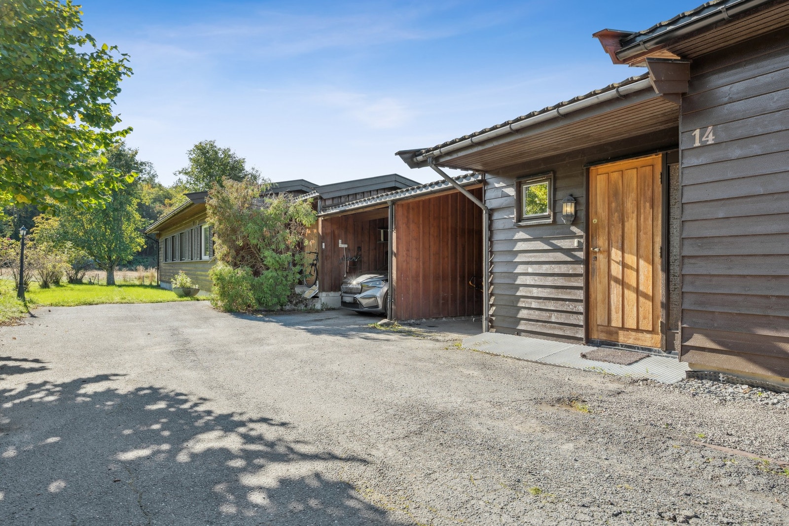 Parkering i carport og en biloppstillingsplass i gårdsplassen. Galleribilde