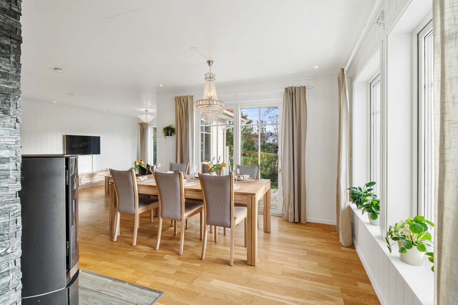 Utgang til terrasse som strekker seg rundt hele fronten av boligen. Galleribilde