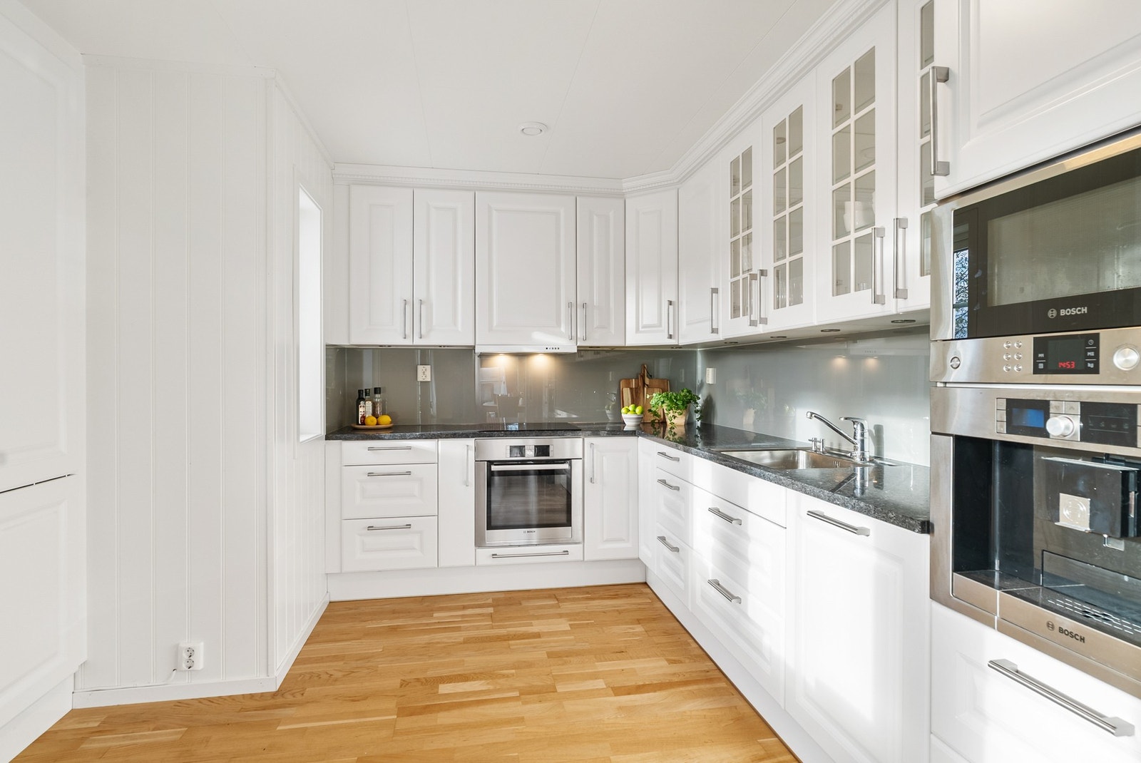 Påkostet kjøkkeninnredning fra JKE med profilerte fronter og benkeplate i hel stein. Galleribilde