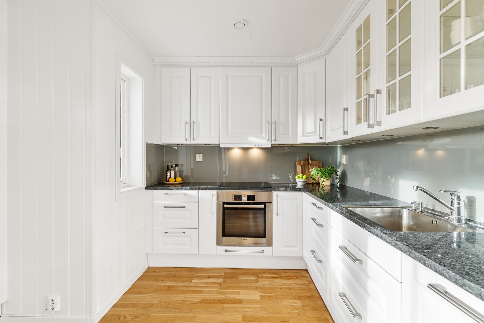 Det er montert en glassplate på veggen mellom benkeplaten og overskapene. Galleribilde