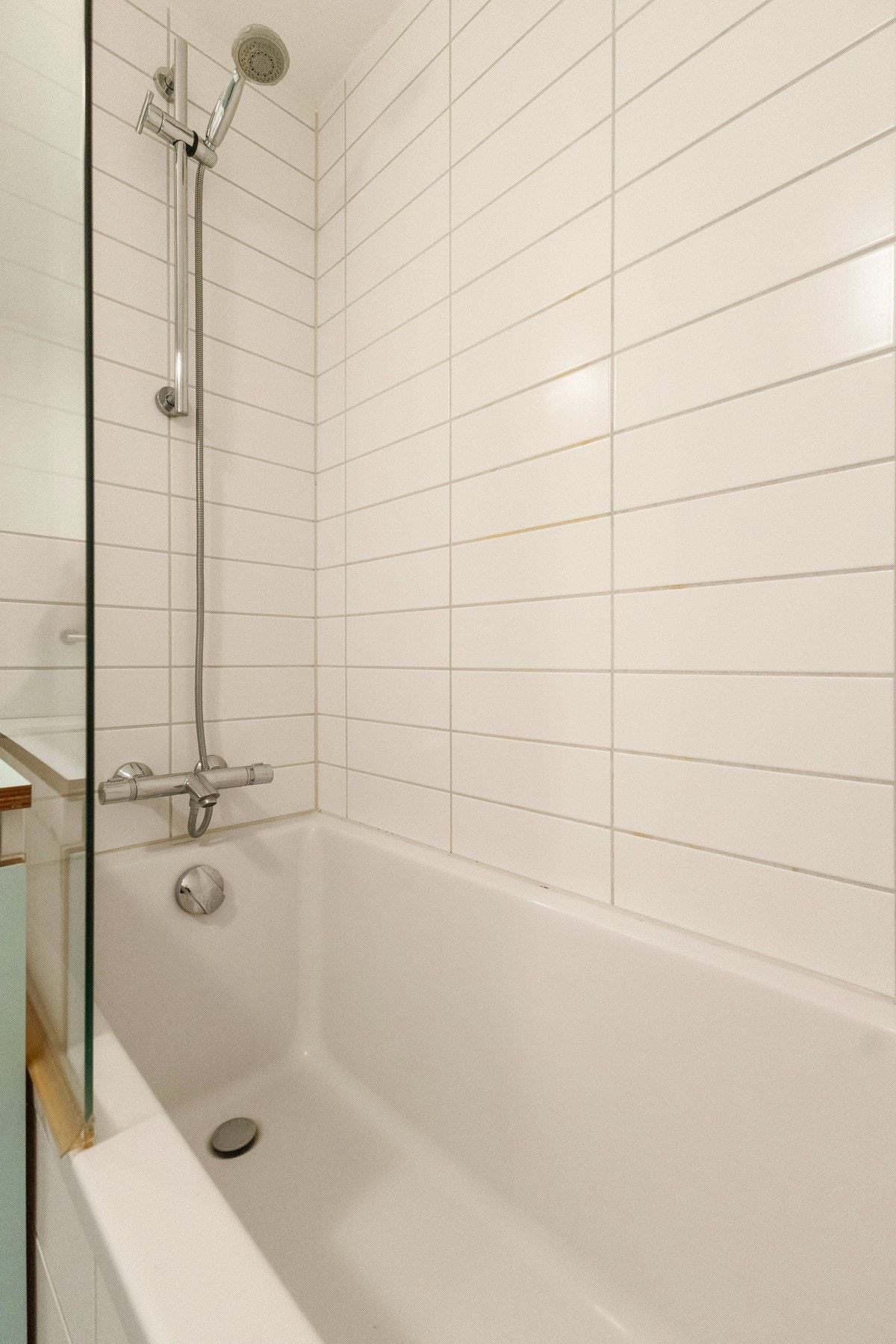 Badet har et innmurt badekar med glassvegg. Galleribilde