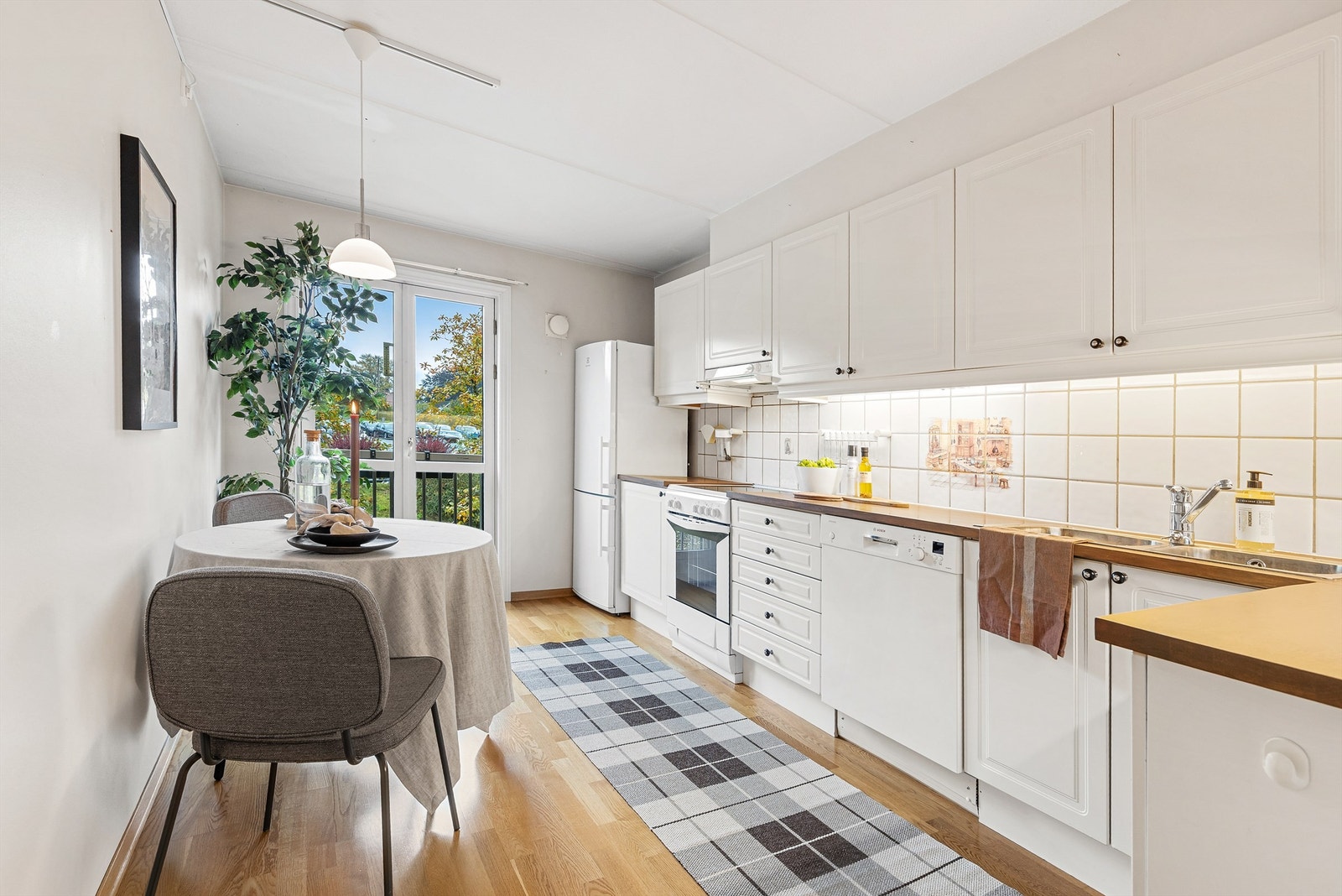 Kjøkken med plass til et lite spisebord. Galleribilde