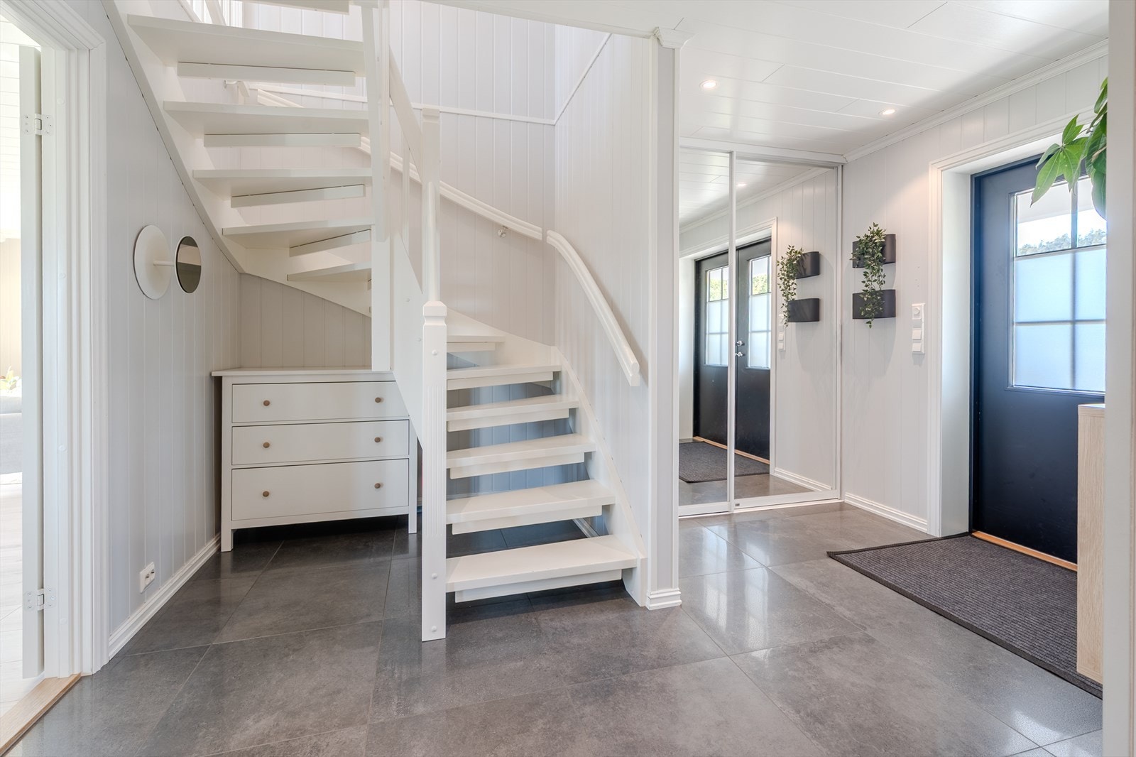 Romslig hall med fliser, skyvedørsgarderobe og trapp til loftstuen Galleribilde