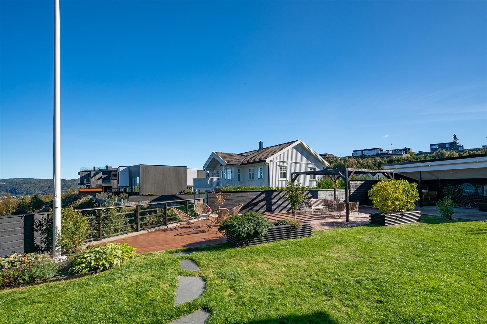 Stort terrasseanlegg og flaggstang i hagen Galleribilde