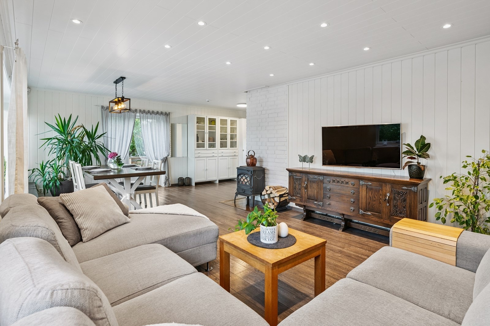 Lys og pen vinkelstue med vedovn. Galleribilde