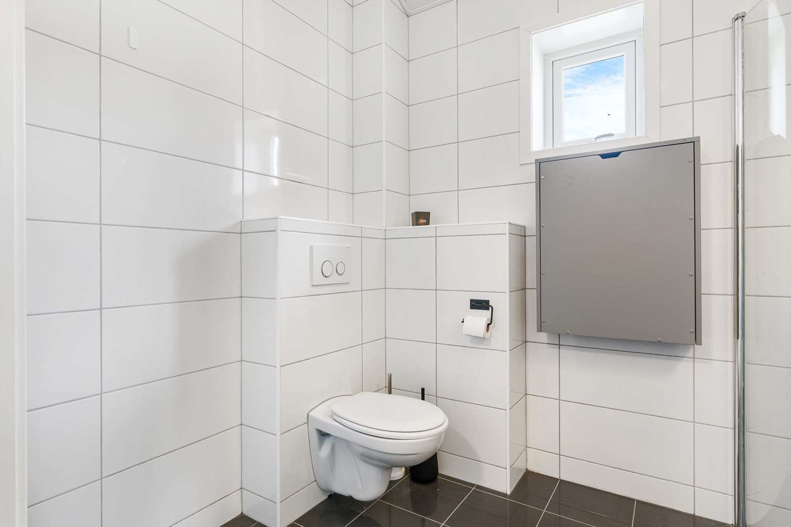 Utstyrt med servantskap, mekanisk avtrekk, veggmontert wc og innfellbare dusjdører. Galleribilde