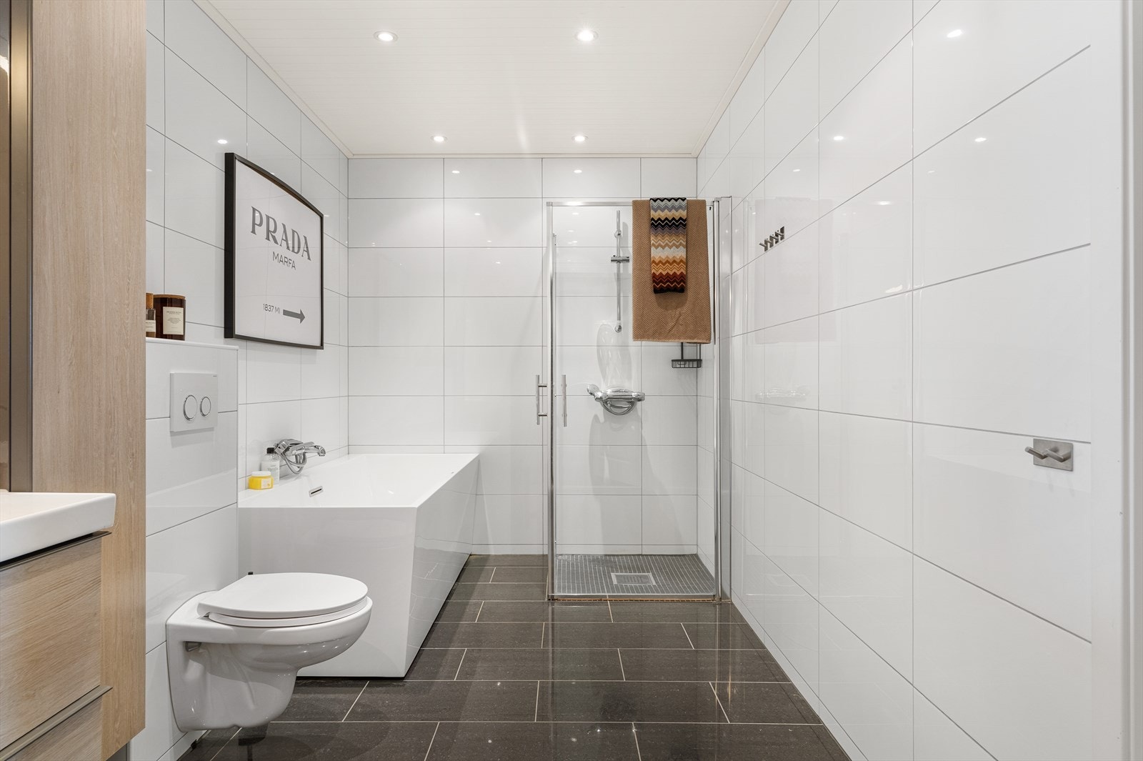 Utstyrt med servantskap, mekanisk avtrekk, veggmontert wc, innfellbare dusjdører og badekar. Galleribilde