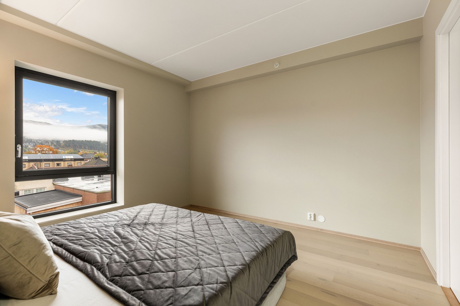 Veggene er malt i samme kalkgrå nyanse som resten av leiligheten, og gulvene har enstavs parkett som gir et moderne og stilfullt preg. Galleribilde