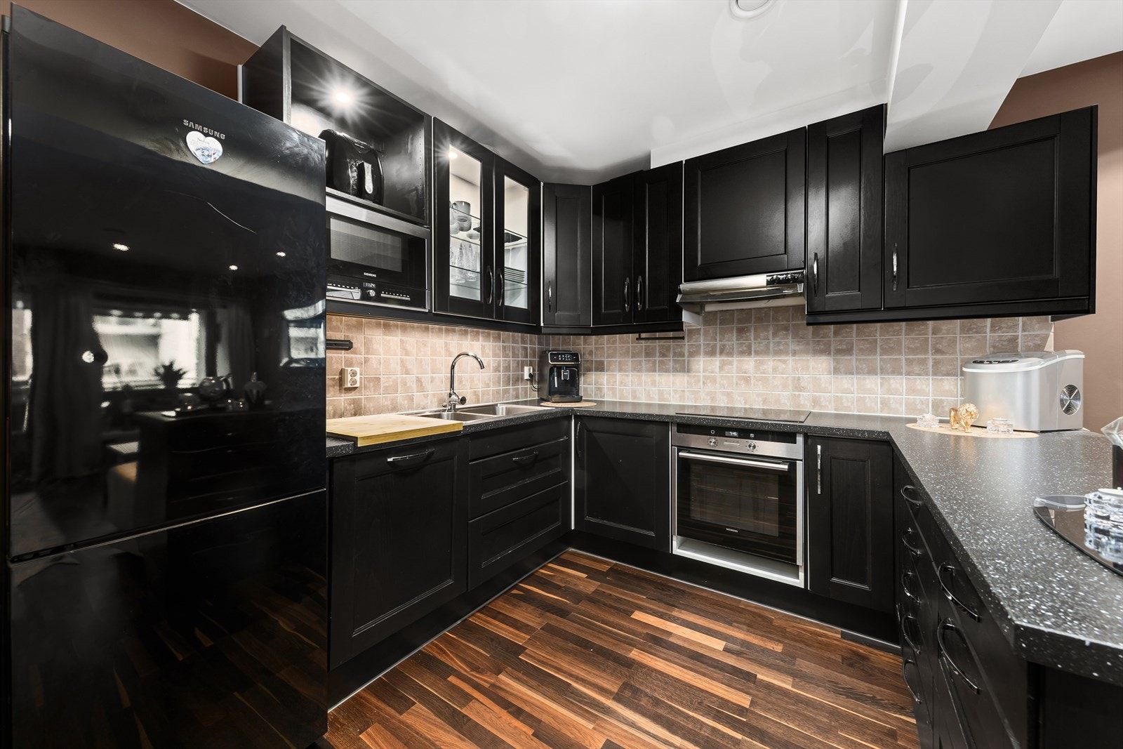 Stilfullt kjøkken med alt en måtte trenge av skap-, skuff- og benkeplass. Galleribilde