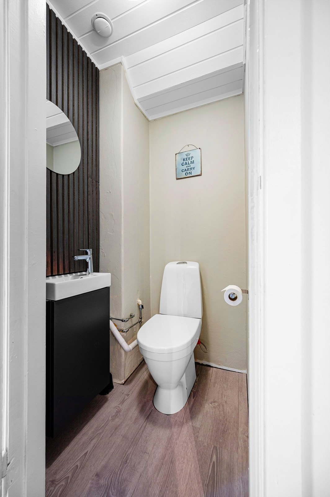 Wc med laminat på gulv, enkel servant og malte vegger. Wc ble pusset opp i 2024 og det ble satt inn nytt toalett, ny servant , nytt batteri og lagt inn varmtvann. Galleribilde