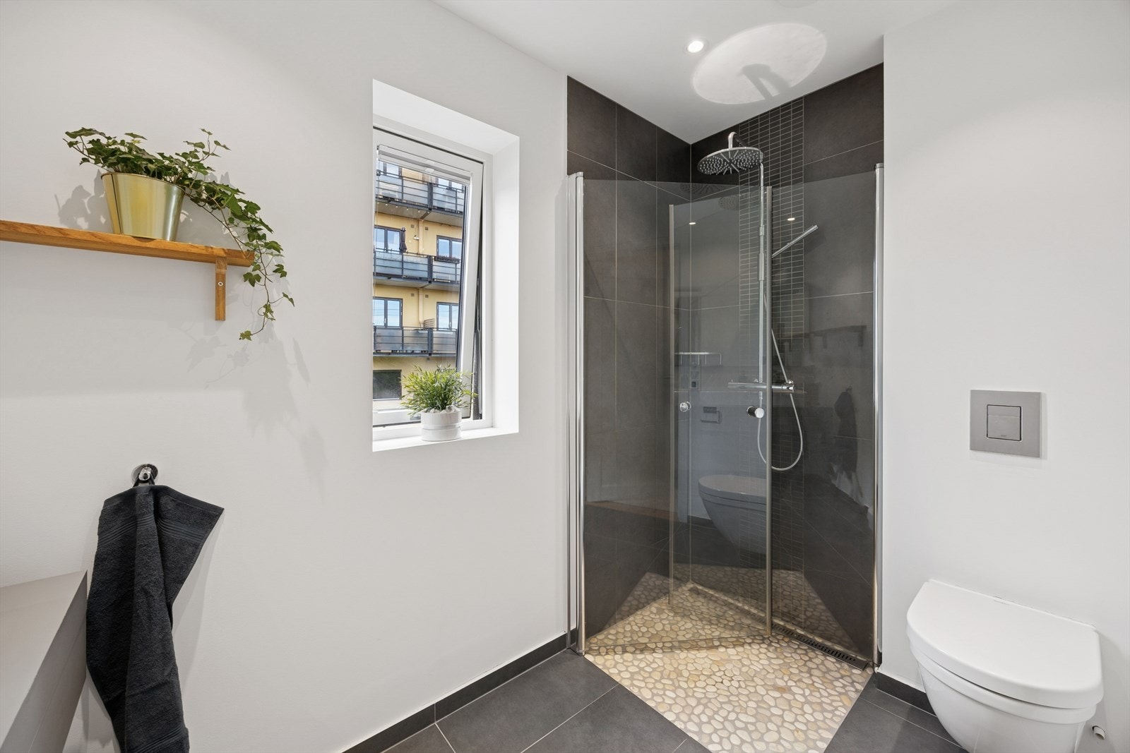 Delikat baderom i 2.etasje utstyrt med vegghengt toalett, dusjhjørne med svingbare glassdører, og heldekkende servant med tilhørende skuffeinnredning. Galleribilde