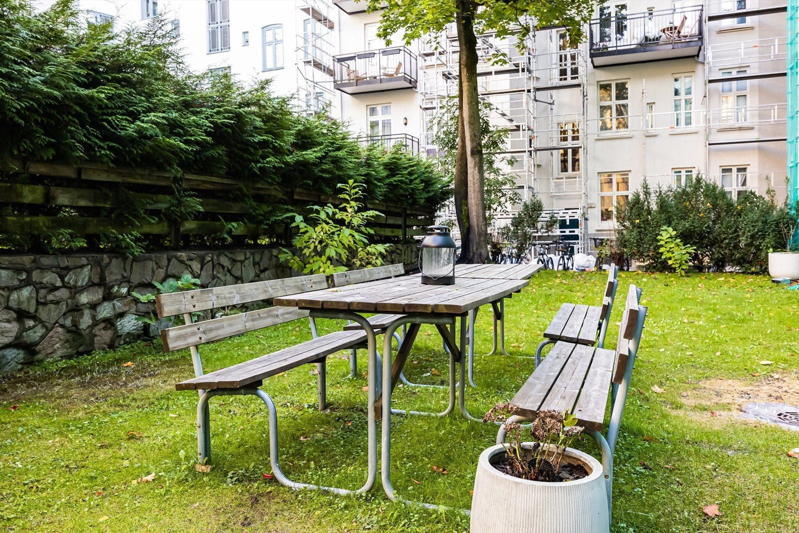 Indre gårdsrom opparbeidet med gressplen, beplantning, sykkelstativ og steinsatte gangarealer. Galleribilde