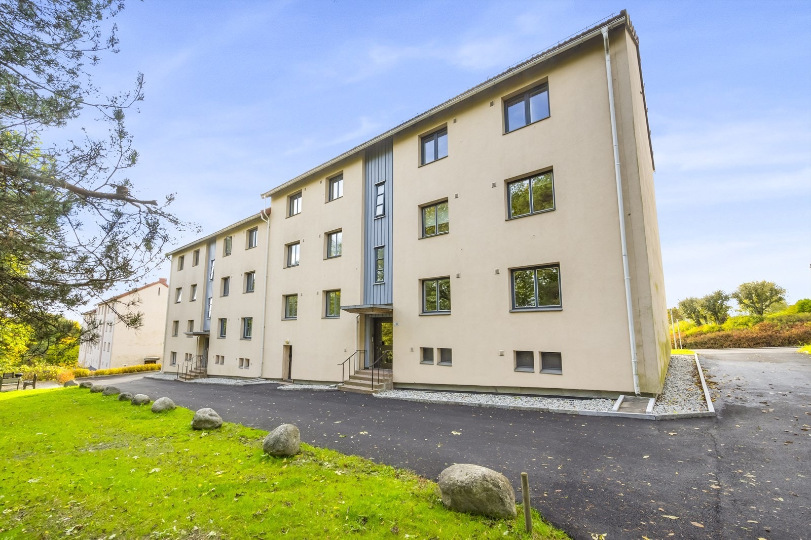 Fellesarealet er pent opparbeidet med asfaltert inngangsparti, plen og beplanting. Galleribilde