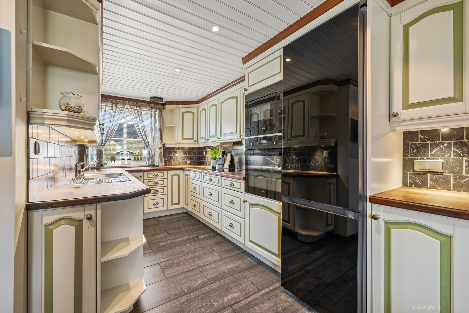 Innredningen har integrerte hvitevarer, herunder oppvaskmaskin, komfyr, platetopp og mikrobølgeovn Galleribilde