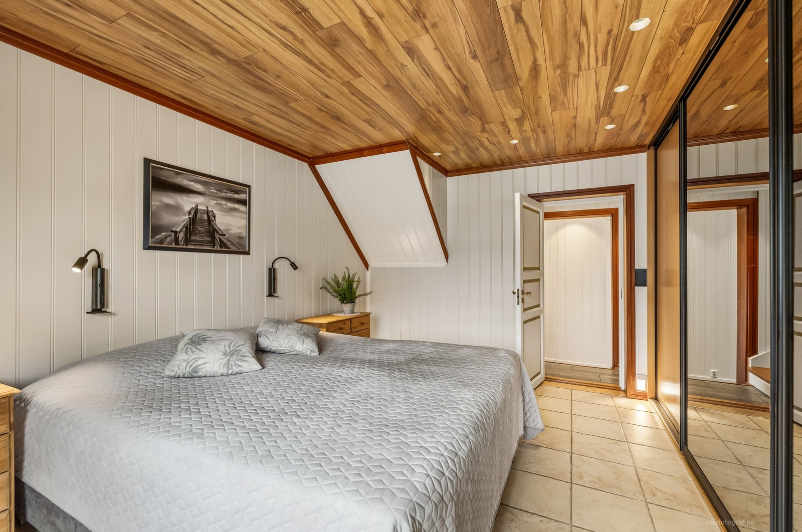 Det er god plass til dobbeltseng og nattbord, samt rikelig oppbevaringsmuligheter i en stor skyvedørsgarderobe Galleribilde