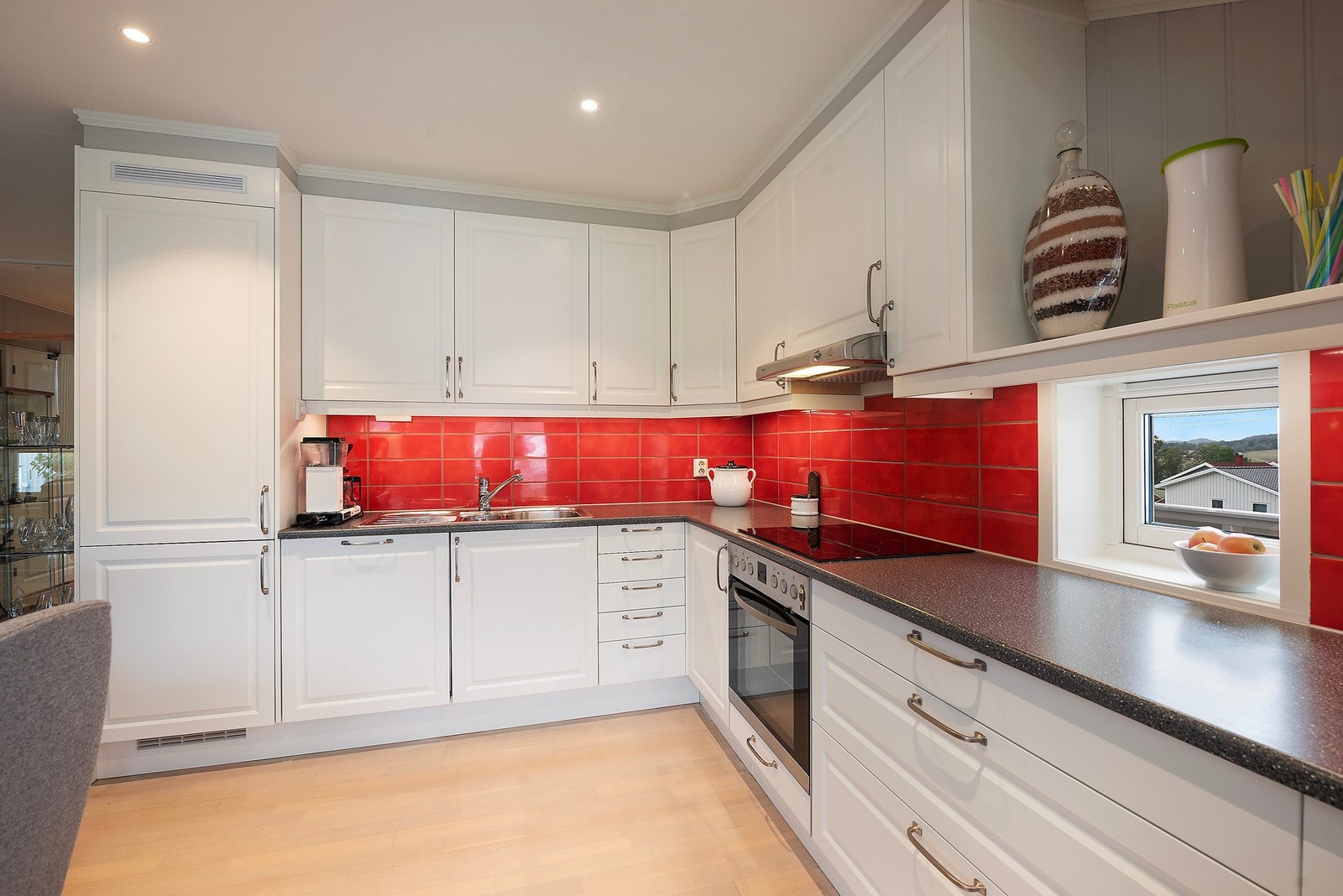 Her har du friske fliser mellom kjøkkenbenk og overskap som både frisker opp rommet og gjør renholdet enkelt Galleribilde