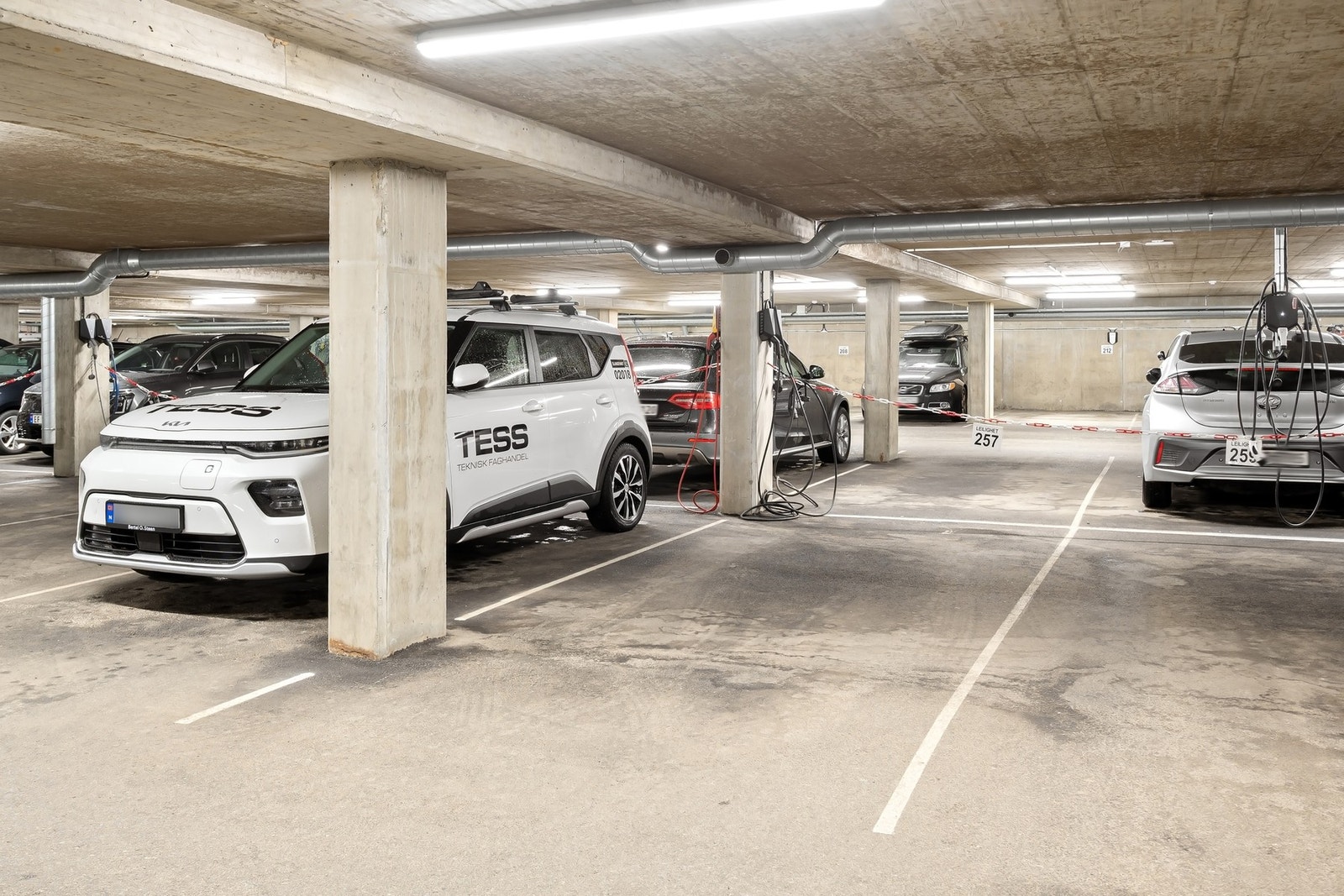 Parkering i garasjekjeller. Det er montert elbil-lader på plassen. Galleribilde