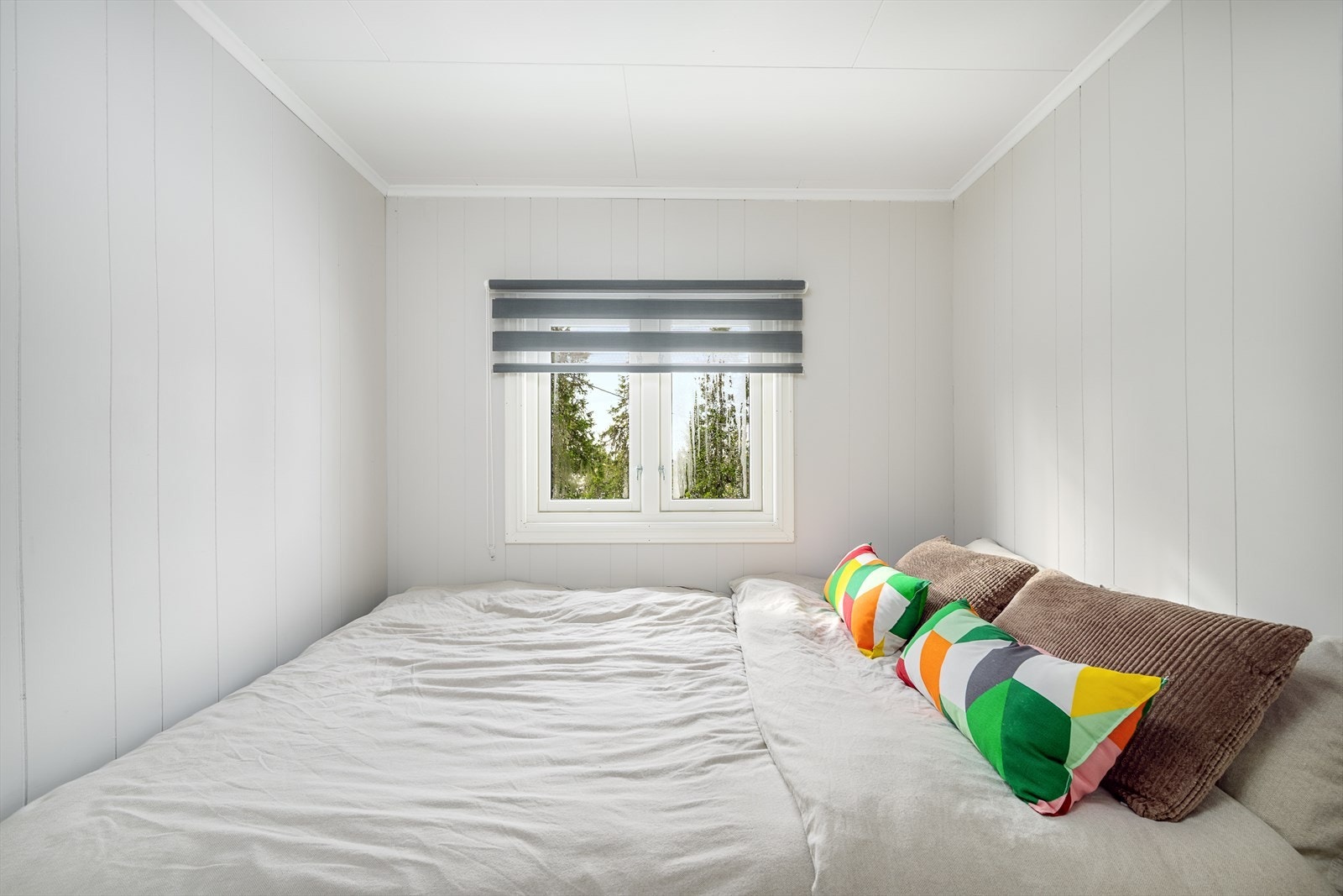 Det er ett soverom i hytta. Lysmallte overflater og innredet med dobbeltseng. Galleribilde