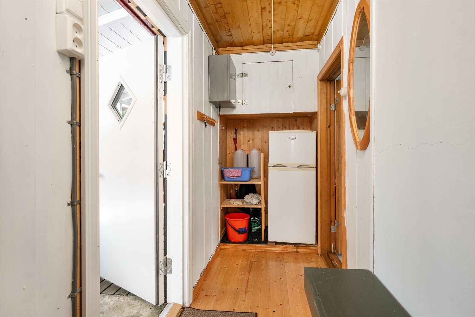 Gangen inn til hytta har tregulv og delvis panelte vegger, delvis plater på vegger. Plass til kjøleskap. Galleribilde