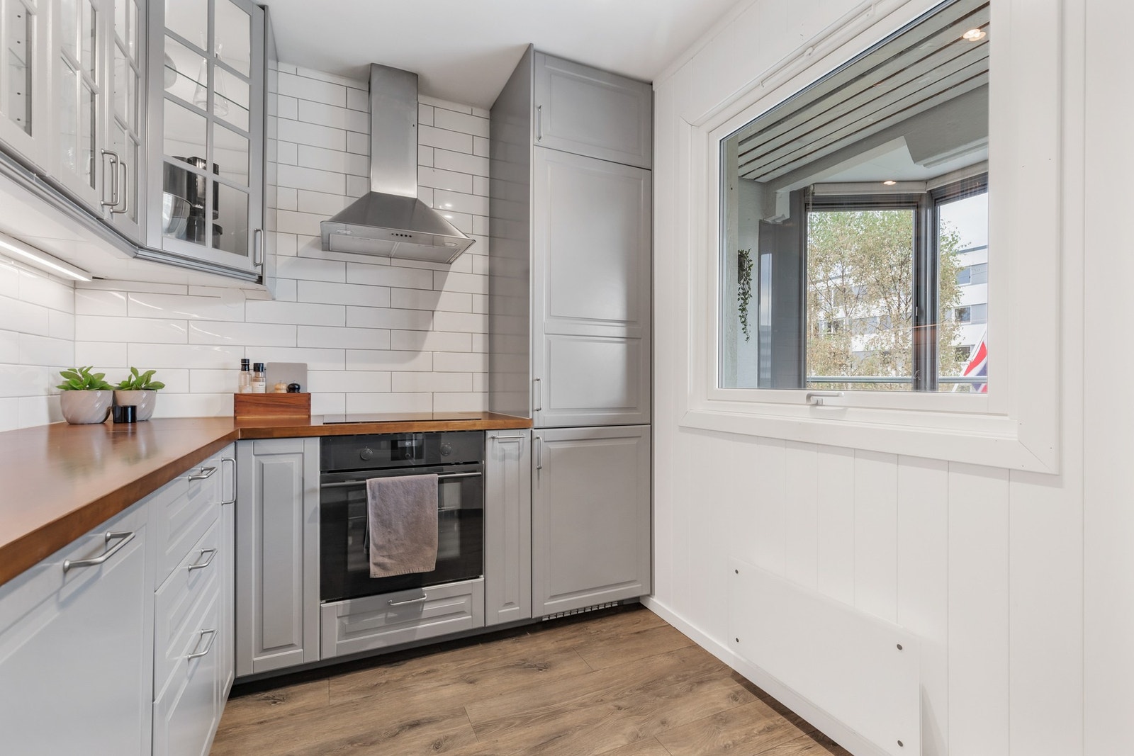 Innredningen har integrerte hvitevarer, herunder kjøl/fryseskap, oppvaskmaskin, platetopp og stekeovn Galleribilde