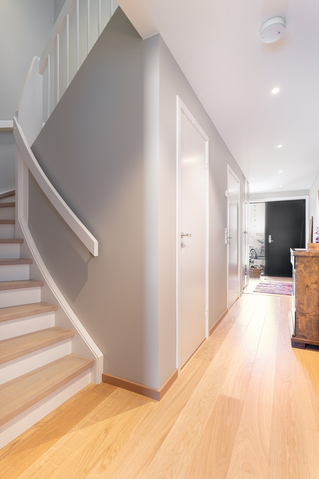 I gangen er det parkett på gulvet og malt tretrapp med eiketrinn opp til 2. etasje. Down-light belysning i tak. inngang til bod som går videre bak trappen. Galleribilde