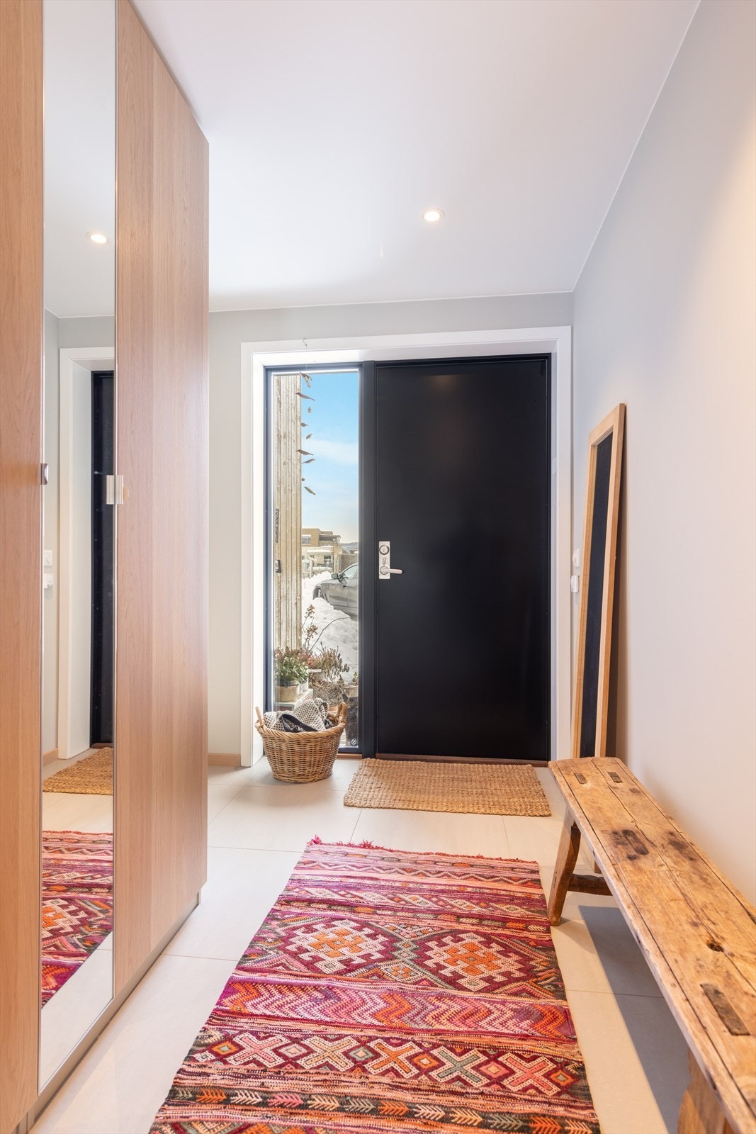 Lys hall møter deg ved inngangsdøren hvor sidevindu i hele dørens høyde tilfører godt med dagslys. Entrèen har store, moderne fliser på gulvet og slette, malte veggoverflater. God plass til sko- og ytterklær i garderobeskap med speildør. Galleribilde