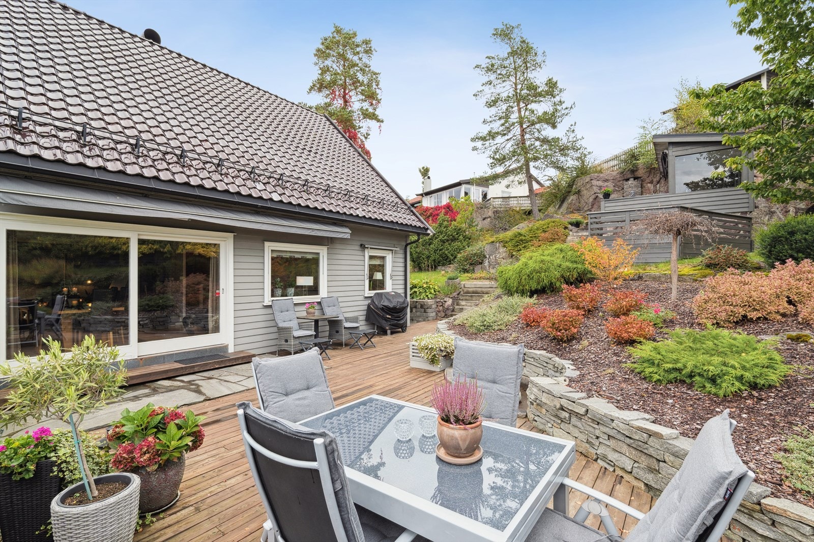 Vakker hage med utestue med peis. Galleribilde