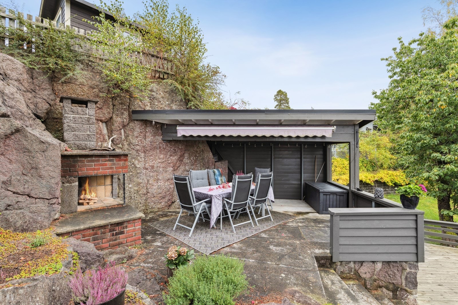 Delvis overbygget utestue med peis. Det er også montert markise. Galleribilde